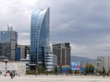 Nowoczesne centrum Ułan Bator z charakterystycznym szklanym wieżowcem Blue Sky Tower i panoramą miasta na tle gór. #18