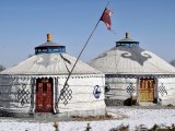 Dwie tradycyjne mongolskie jurty z ozdobnymi drzwiami na zaśnieżonym stepie, symbol koczowniczego życia w Mongolii. #12