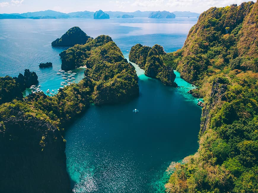 Laguny i wapienne skały El Nido na Palawanie – rajski krajobraz z tradycyjnymi filipińskimi łodziami bangka, popularny punkt wycieczek objazdowych na Filipinach